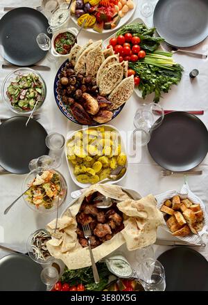 Hausgemachtes Abendessen auf dem Tisch. Kartoffeln mit Dill serviert. Fleisch, Gemüse, Salat. Warme Atmosphäre der traditionellen Küche. Stockfoto