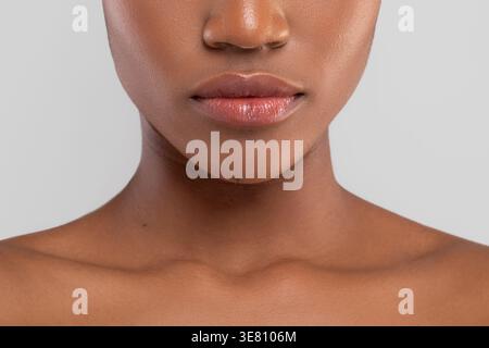 Abgeschnittenes Bild der Schwarzen Frau vor grauem Hintergrund im Studio Stockfoto
