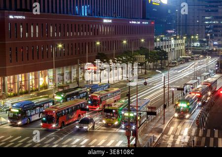 Nachtszene in der Cheongpa-Ro Straße in Jung-gu, Seoul, Südkorea. Mehrere Busse stehen auf der Reihe, deren Lichter die Straße beleuchten. Stockfoto