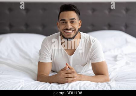 Ein arabischer Mann mit gefesselten Händen, der auf dem Bett liegt Stockfoto