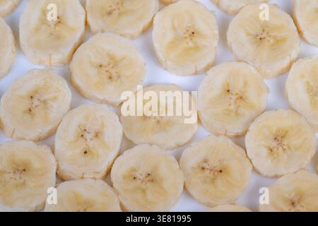 Natürliche Bananenringe mit Detailansicht. Helles Atelierbild von geschnittenen Reifen Bananen. Detaillierte Nahaufnahme frischer Bananenscheiben in Studiobeleuchtung Stockfoto