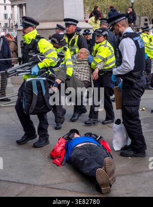 London, UK.11. April 2026. Pro-palästinensischer Demonstrant legt sich auf den Boden, während ein anderer Demonstrant zum Polizeilager getragen wird, nachdem er von Metropolitan Police Officers verhaftet wurde. Verteidigen Sie unsere Geschworenen-Demonstration am Trafalgar Square, Zentrum von London, gegen das Verbot der Palästinensischen Aktion. Der Oberste Gerichtshof hat das Verbot der Palästinensischen Aktion für rechtswidrig befunden, aber es ist noch nicht offiziell aufgehoben worden. Im Zusammenhang mit dieser friedlichen Unterschriftenkampagne wurden bisher fast 3.000 Verhaftungen unter „Terroranklagen“ verhaftet. Quelle: Ian Humphreys/Alamy Live News Stockfoto
