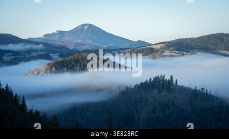 Spätherbst Landschaft mit Nebel, der durch das Tal und die Berge ragt, Slowakei Stockfoto