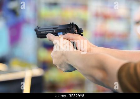 Mit einer Schwarzluftpistole auf einer traditionellen Schießgalerie auf einer thailändischen Tempelmesse, die lokale Festivalspiele und Präzision repräsentiert. Stockfoto