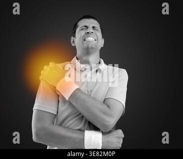 Schuss eines jungen Athleten mit einer Schulterverletzung in Schwarz oder weiß und einem hellroten Licht im Schmerz Stockfoto