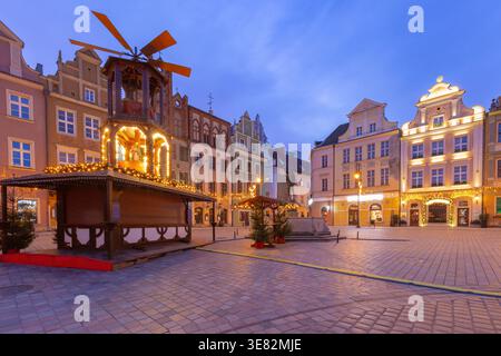 Blick am frühen Morgen auf die Weihnachtsmarktstände und festliche Lichter auf dem alten Marktplatz in Posen, Polen, in der blauen Stunde vor Sonnenaufgang. Stockfoto