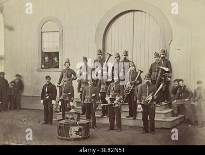 Die Band des 10th Veteran Reserve Corps posierte mit Musikinstrumenten vor einem Gebäude in Washington, D.C. und zeigte uniformierte Soldaten während der letzten Periode des Amerikanischen Bürgerkriegs Stockfoto
