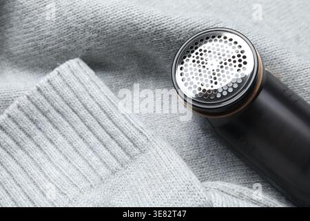 Stoffrasierer auf grauem Pullover, Nahansicht Stockfoto