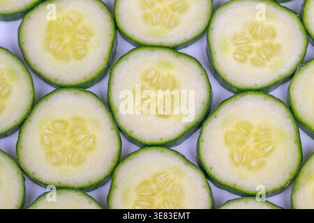 Entgiftungsgurkenscheiben für infundiertes Wasser, dünne Runden bieten Erfrischung und Sommerhydratation, geeignet für Getränke, Rezepte und saubere Essensbilder Stockfoto