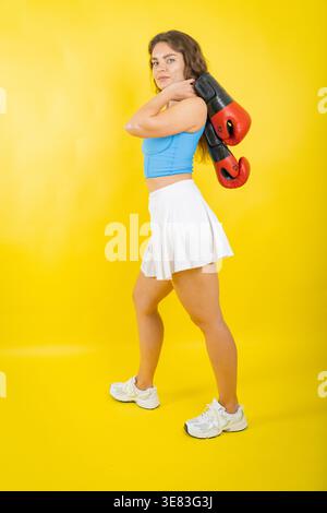 Selbstbewusste junge Frau, die Boxhandschuhe für das Training trägt Stockfoto