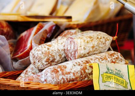 Villach, Österreich - 05. September 2025: Verschiedene Salami- und Wurstsorten in einem gewebten Korb, mit ERMES Funghi-Label, mit Gourmetqualität und Stockfoto