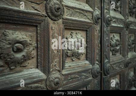 Geschnitzte Holztür mit antiken architektonischen Details, dekorativen Blumenmustern und strukturierten Oberflächen in parma oder bologna, italien Stockfoto