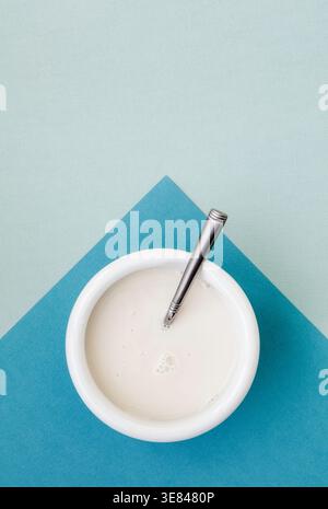 Schüssel mit frischer Mandelmilch auf duofarbigem, glattem Hintergrund Stockfoto