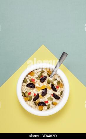 Weiße Schüssel mit Hafer und Früchten Stockfoto