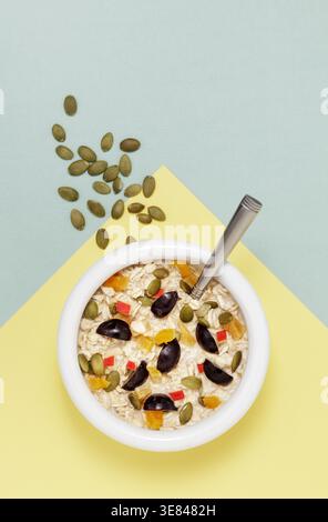 Weiße Schüssel mit Hafer, Früchten und Kürbiskernen Stockfoto