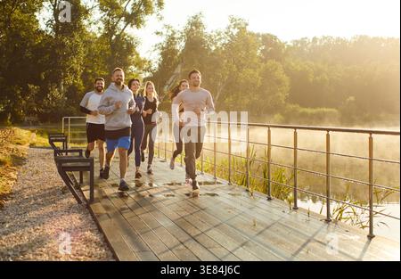 Aktive Läufer laufen gemeinsam Marathon, Morgenlauf der Freunde im Sommerpark Stockfoto