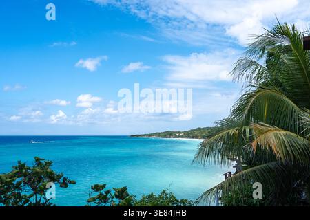 Klares türkisfarbenes Wasser trifft auf weißen Sand und üppiges Grün am Bira Beach in Sulawesi, Indonesien, unter einem hellen tropischen Himmel Stockfoto