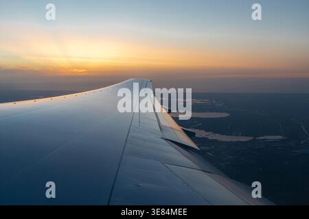 Ein spektakulärer Sonnenuntergang mit erstaunlichen Sonnenstrahlen und Farben am Horizont weit weg über dem Flügel eines Flugzeugs auf dem Weg nach Kapstadt in South AF Stockfoto