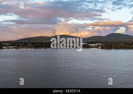 Blick über die Pipers Bay in Forster, New South Wales, Australien, mit Sonnenuntergang hinter einem bewölkten Himmel. Stockfoto