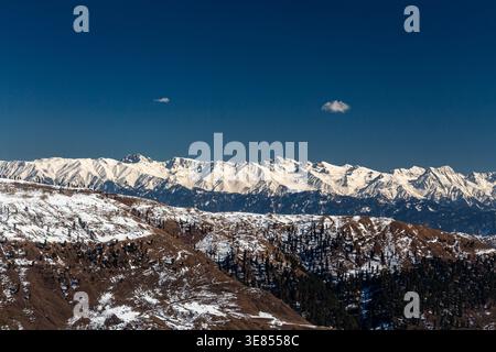 Blick auf die zerklüftete, schneebedeckte Bergkette vor dem tiefblauen Himmel, einen ruhigen Kontrast aus kaltem weiß und warmen Erdtönen, Lasdana, Azad Kaschmir Stockfoto