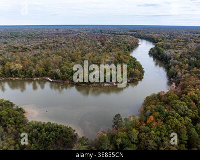 Die Luftaufnahme eines sich windenden Flusses reflektiert den gedämpften Himmel und schneidet durch einen Wandteppich herbstlicher Wälder in einer ruhigen Szene in Fort Motte, South Carolin Stockfoto