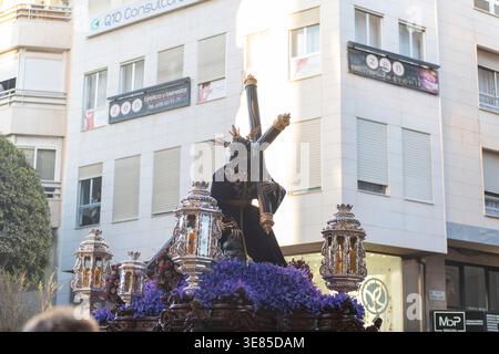 Almeria, Spanien - 30. März 2026: Eine Statue Jesu mit dem Kreuz wird während einer Karwoche in der Stadt auf einem mit Blumen bedeckten Wagen ausgestellt Stockfoto