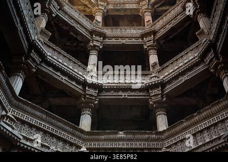 Ansicht nach oben mit den massiven geschnitzten Säulen und der mehrstöckigen Struktur des Adalaj-Stiefels, Adalaj ni Vav, Ahmedabad, Gujarat, Indien, Asien. Stockfoto