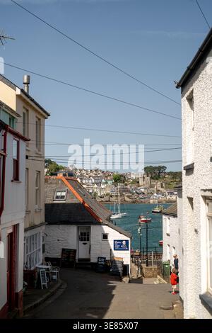 Blick auf eine enge Straße in Polruan in Richtung der Flussmündung des Flusses Fowey, Cornwall, Großbritannien Stockfoto