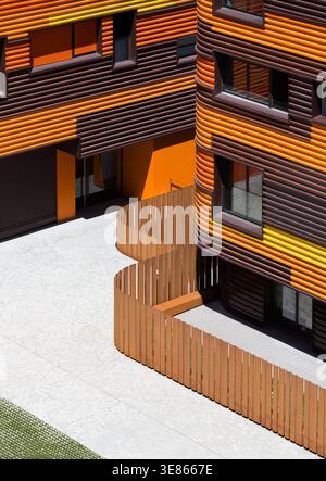 Ein modernes Passivhaus mit leuchtendem Orange und Braun, das Energieeffizienz und Nachhaltigkeit betont, ideal für modernes Coliving Stockfoto