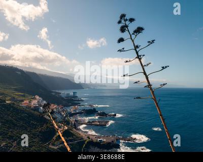 Panoramablick auf El Pris an der Nordküste Teneriffas, Canarias, mit zerklüfteten Klippen, Atlantik-Surf und Mount Teide in der Ferne unter weichen Wolken Stockfoto