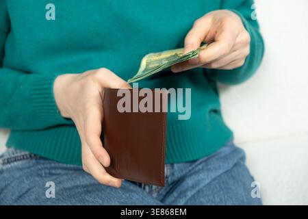 Hände haben die Papierscheine in Nahaufnahme in die Brieftasche gelegt Stockfoto