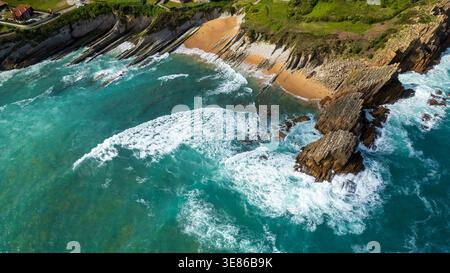 Atemberaubender Blick aus der Luft auf den Strand von Arnia an der Costa Quebrada. Das Bild zeigt einzigartige geschichtete geologische Flyschformationen, türkisfarbenes Wasser mit weiß Stockfoto