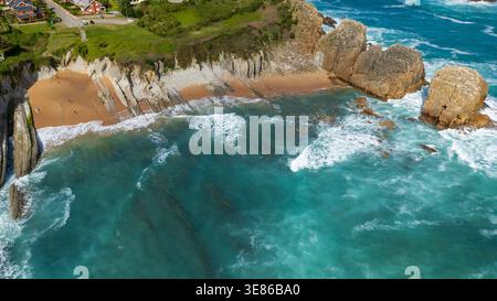 Atemberaubender Blick aus der Luft auf den Strand von Arnia an der Costa Quebrada. Das Foto zeigt einzigartige geologische Flyschformationen, türkisfarbenes Wasser mit weißem Schaum, A Stockfoto