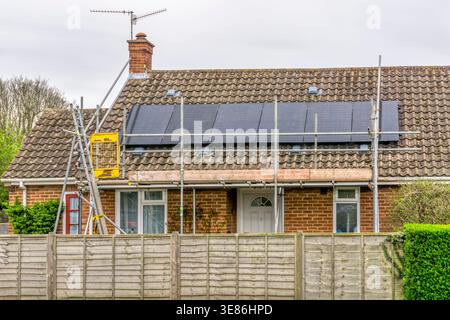 Neue Solarpaneele werden in einem Norfolk-Bungalow installiert. Stockfoto
