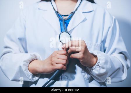 Ein junger Arzt, der ein Stethoskop hält Stockfoto