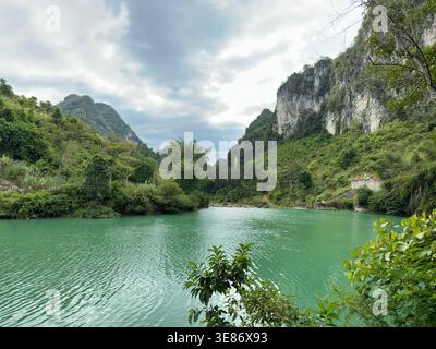 Ruhiger türkisfarbener Fluss, der sich durch die üppigen grünen Berge in Guangxi, China, schlängelt Stockfoto