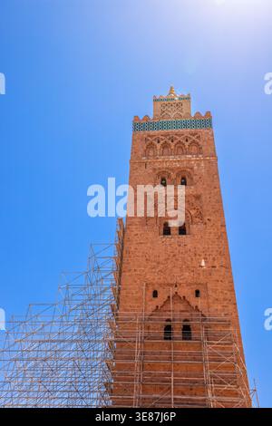 Niedrigwinkelaufnahme des majestätischen Minaretts der Koutoubia-Moschee mit Gerüsten vor tiefblauem Himmel in Marrakesch, Marokko Stockfoto