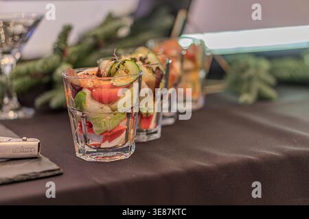 Nahaufnahme von drei farbenfrohen Cocktail-gefüllten Shot-Gläsern, möglicherweise garniert mit Obst, in einem schwach beleuchteten Casino-Ambiente Stockfoto