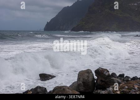 Mächtige Atlantikwellen stürzen unter dunklen Klippen an der Nordküste Madeiras bei Seixal und Sao Vicente auf die felsige Küste, mit Nebel und Überkraut Stockfoto