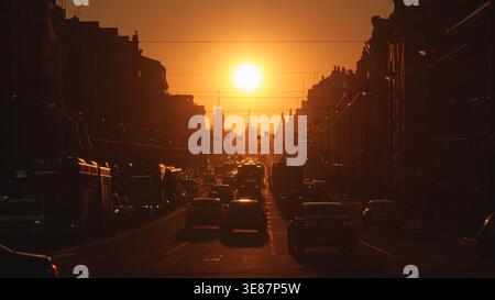 Sankt Petersburg, Russland - 10. April 2026, Panoramablick auf den Newski-Prospekt, Autos auf der Straße, Menschen auf Gehwegen, bei Sonnenuntergang mit heller Sonne, immer Stockfoto