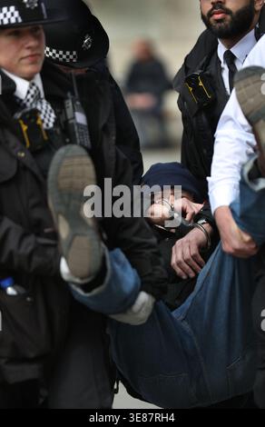 London, England, Großbritannien. April 2026. Ein Demonstrant wird in Handschellen weggetragen, nachdem er während des Protestes verhaftet wurde. Nach dem Urteil einer Jury von Richtern bei der gerichtlichen Überprüfung Anfang des Jahres, in dem das Verbot der pro-palästinensischen direkten Aktionsgruppe Palestine Action durch die Regierung als rechtswidrig befunden wurde, saßen über 500 Anhänger der Verteidigung auf dem Trafalgar Square und hielten Schilder mit der Aufschrift: "'Ich bin gegen Völkermord. Ich unterstütze die Palästinensische Aktion". Die Regierung soll gegen das Urteil Berufung einlegen, und bis zu dessen Abschluss ist die Unterstützung für die Palästinensische Aktion technisch noch immer nicht abgeschlossen Stockfoto