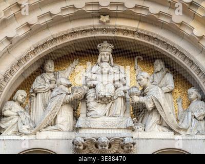 Die Steinschnitzerei zeigt eine königliche Madonna und ein Kind. Engel und Figuren umgeben sie in Ehrfurcht. Hinter den Skulpturen glänzt Blattgold. Ruhe e Stockfoto