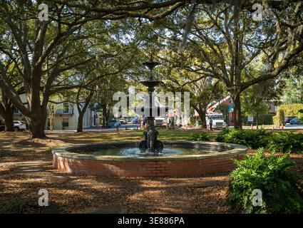 Savannah, GA - USA - 23. März 2026 Eine beschauliche Szene am Lafayette Square, wo ein klassischer Eisbrunnen unter weitläufigen, in Spanisch überzogenen Eichen steht Stockfoto