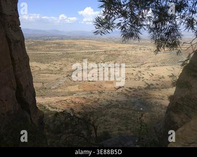 Blick von der Abuna Yemata Guh Felsenkirche durch Bäume zu einem weiten Tal und entfernten Bergen, Tigray, Äthiopien Stockfoto