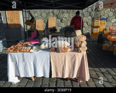 Marktszene im Freien mit Händlern, die frisch gebackenes Brot und hausgemachtes Gebäck an einem Verkaufsstand verkaufen und eine Vielzahl traditioneller Backwaren anbieten Stockfoto