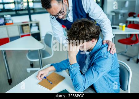 Der Lehrer unterstützt den Lernenden mit Lernschwierigkeiten während des Unterrichts. Stockfoto