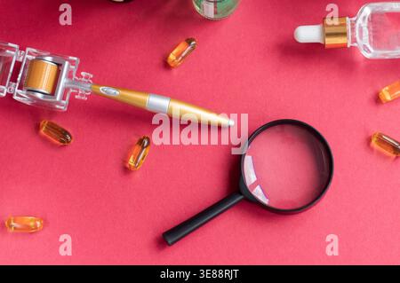 Vergrößerungsglas vor dem Hintergrund von Gesichtsseren und Dermoroller Stockfoto
