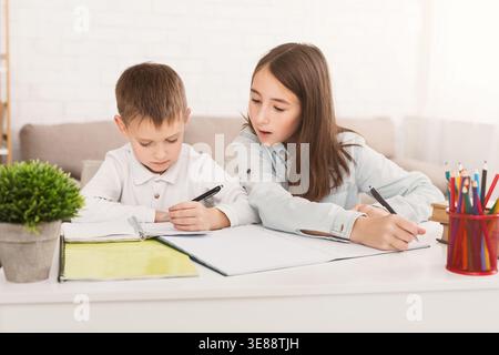 Zu Hause lernen. Schwester hilft Bruder bei Hausaufgaben Stockfoto