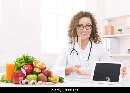 Ernährungsarzt mit Gemüse und Obst mit leerem digitalen Tablet Stockfoto