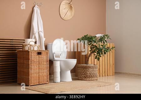 Das Innere des Toiletten mit Toilettenschüssel, Korb und Bademantel Stockfoto